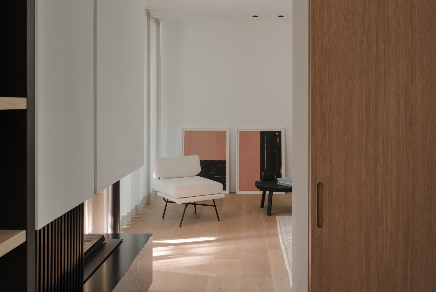 Abgesenkter Wohnbereich mit natürlichen Materialien und einem doppelgeschossigen Kamin