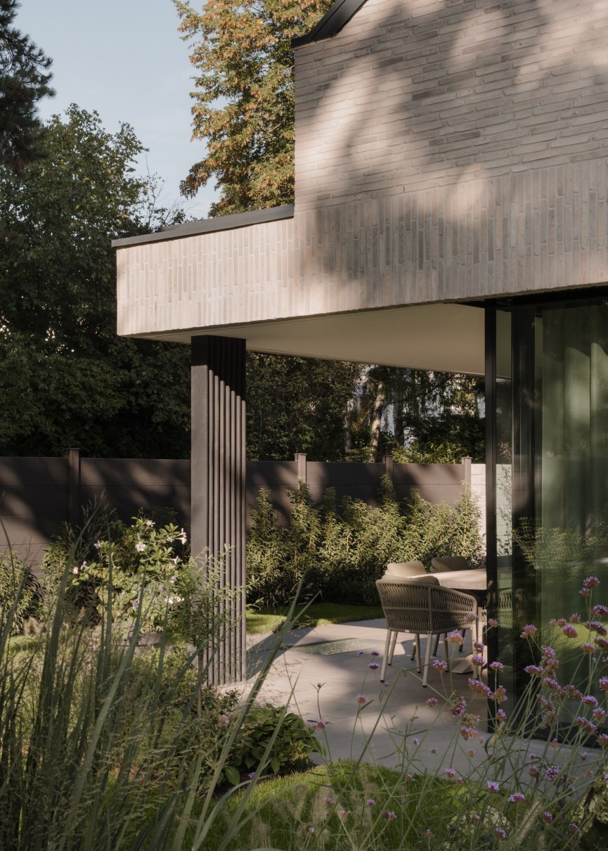 Wohnbereich mit großzügiger Fensterfront und doppelgeschossigem Kamin in Galerie