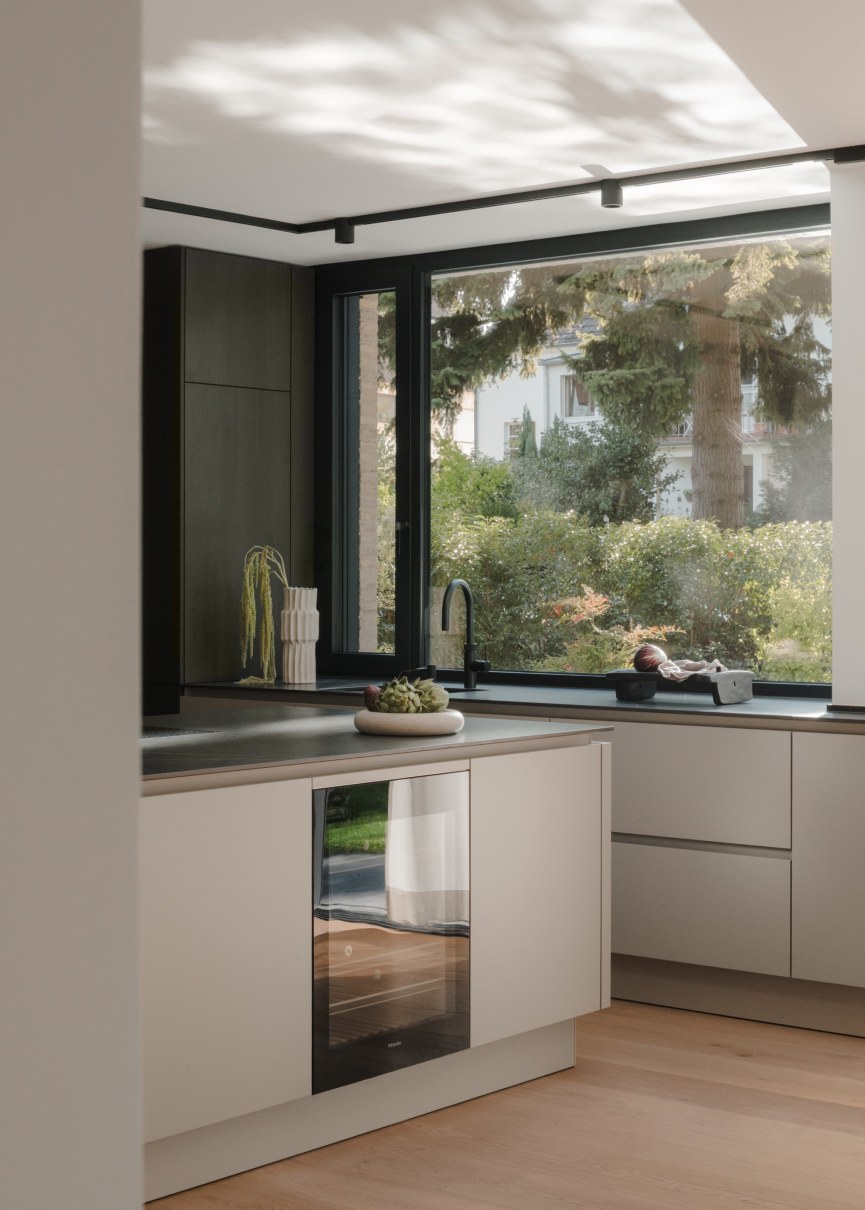 Rückansicht eines Einfamilienhauses mit grosszügigen Glaselementen und Besenstrichfassade