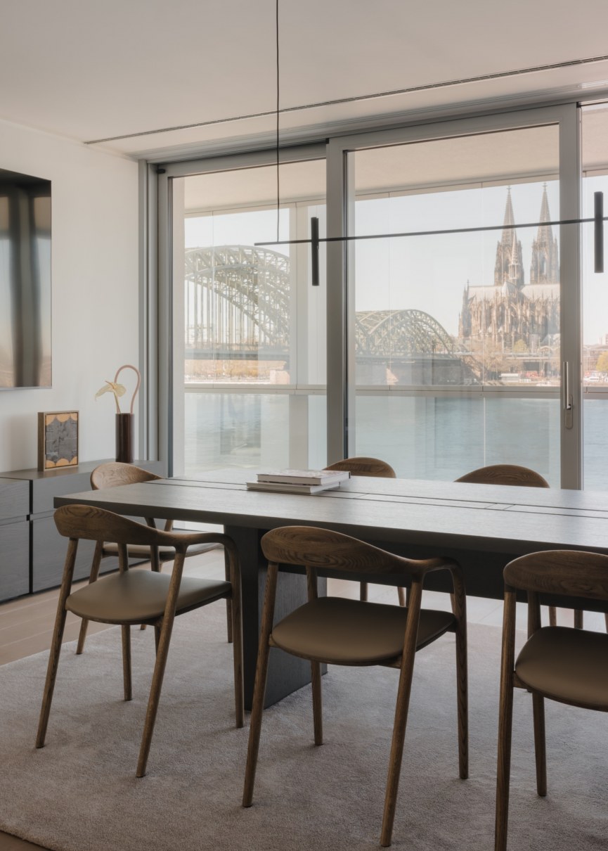 Wohnbereich mit großzügiger Fensterfront und doppelgeschossigem Kamin in Galerie