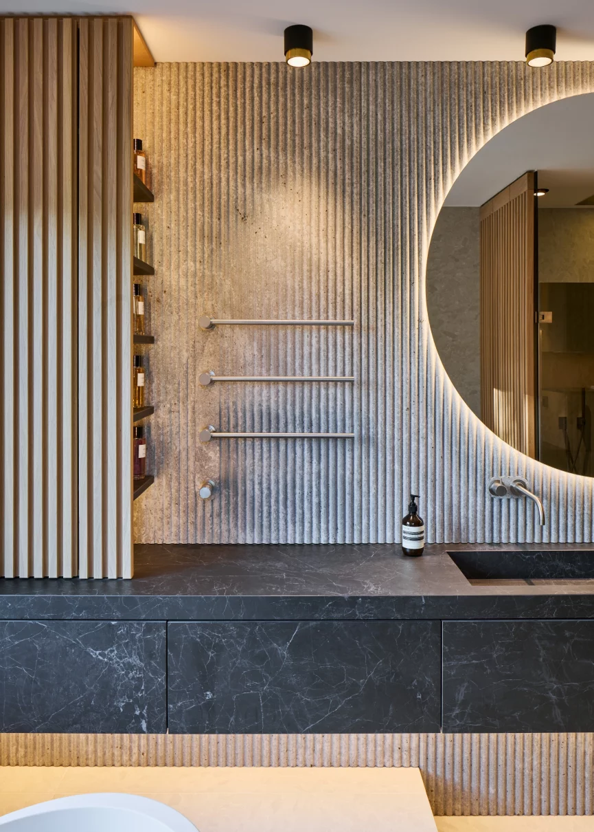 Luxuriöses Badezimmer mit Natursteinrückwand, massangefertigtem Keramikwaschtisch und imposanten Spiegel