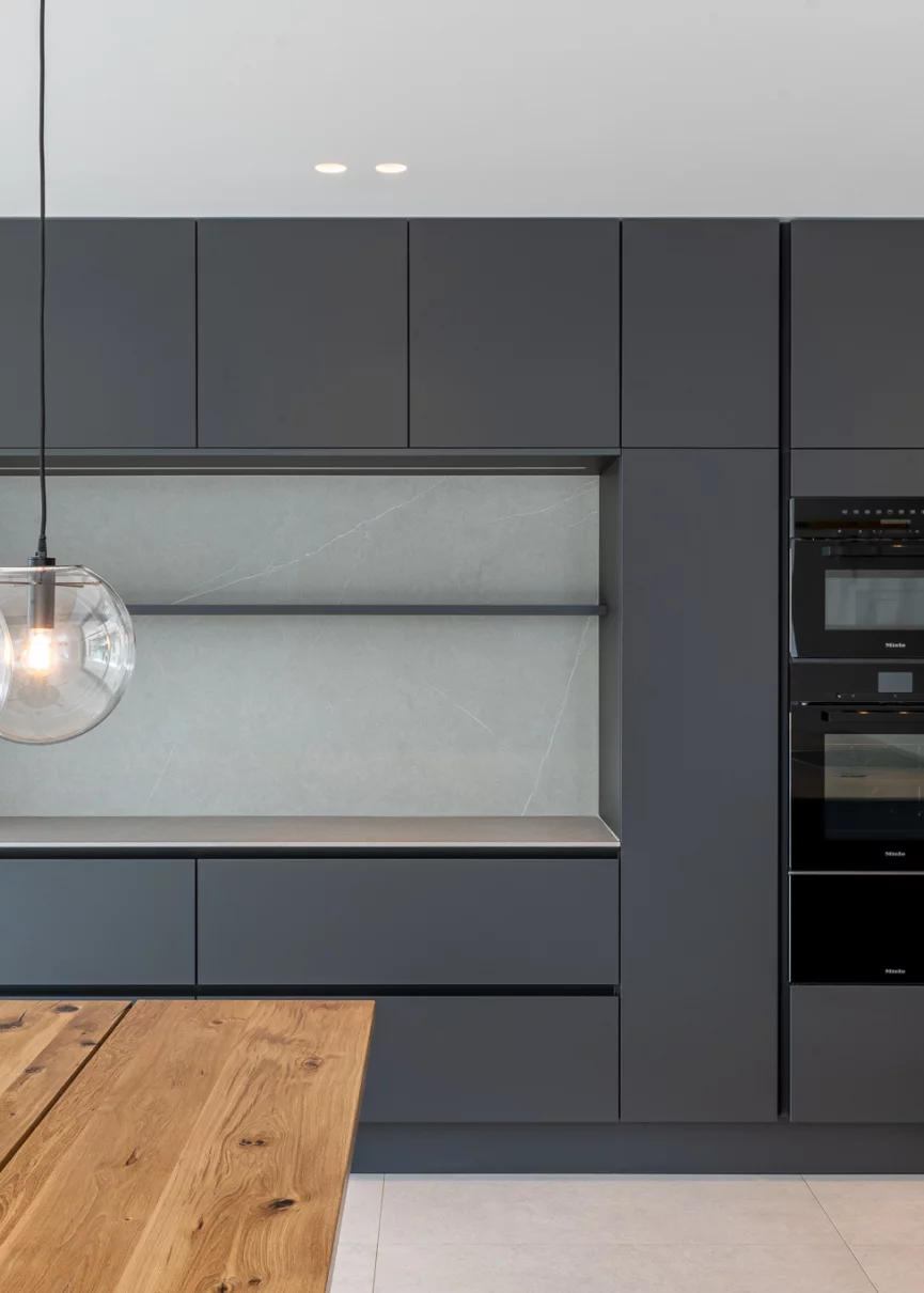 Schwarze Siematic Küche mit Eiche Esstisch und ClassiCon Leuchten über dem Esstisch